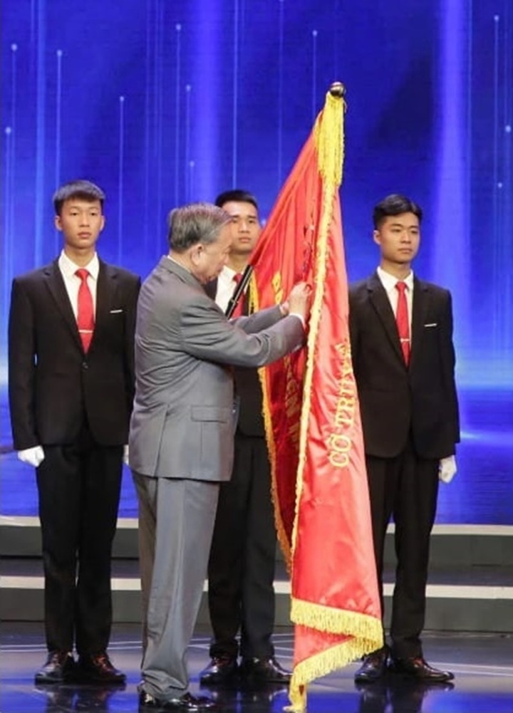 Tổng Bí thư Tô Lâm gắn Huân chương Lao động hạng Nhất lên lá cờ truyền thống của Đài Truyền hình Việt Nam. (Ảnh: VTV)